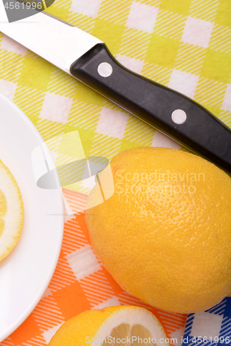 Image of Halved lemon and a knife on a white plate