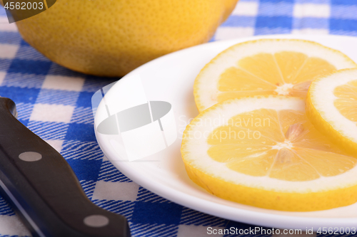 Image of Halved lemon and a knife on a white plate