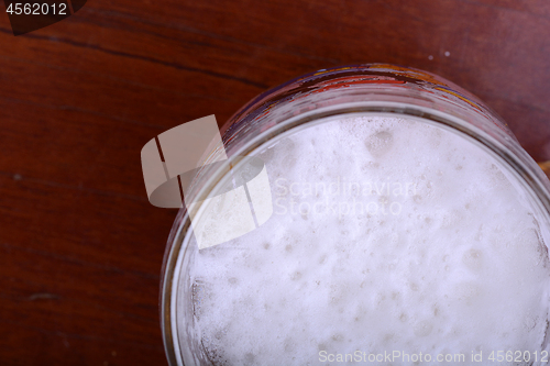 Image of Glass of beer foam over wooden table