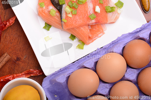 Image of fresh salmon fillet on white plate. red pepper, cinnamon and lemon