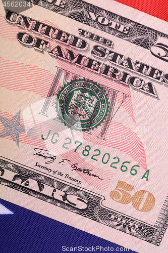 Image of fifty dollar bill in front of the American flag