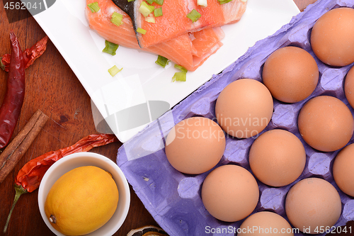 Image of fresh salmon fillet on white plate. red pepper, cinnamon and lemon