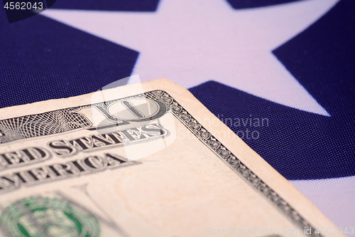 Image of ten dollar bill in front of the American flag