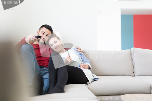 Image of Young couple on the sofa watching television