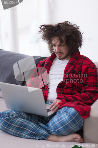 Image of man freelancer in bathrobe working from home