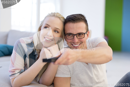 Image of Young couple on the sofa watching television