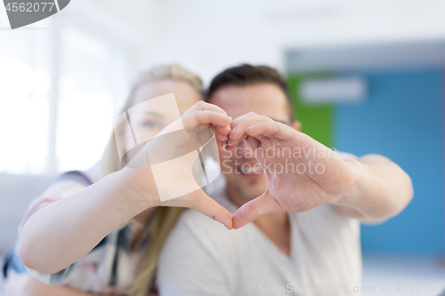 Image of couple making heart with hands