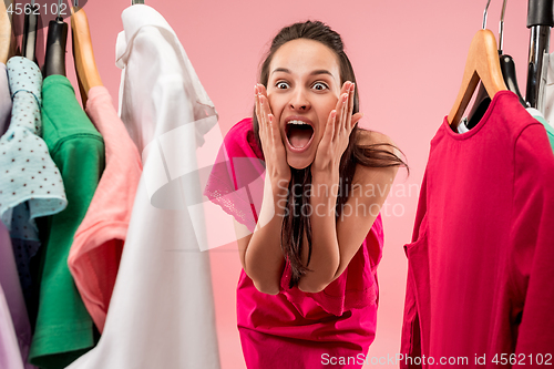 Image of The young pretty girl looking at dresses and try on it while choosing at shop