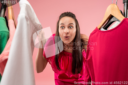 Image of The young pretty girl looking at dresses and try on it while choosing at shop