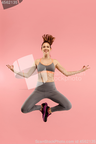 Image of Full length of pretty young woman with mobile phone while jumping