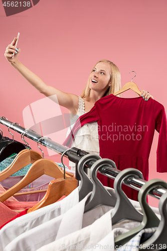 Image of The young pretty girl looking at dresses and try on it while choosing at shop