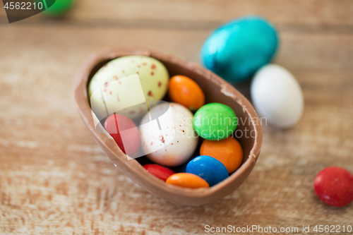 Image of chocolate easter egg and candy drops on table