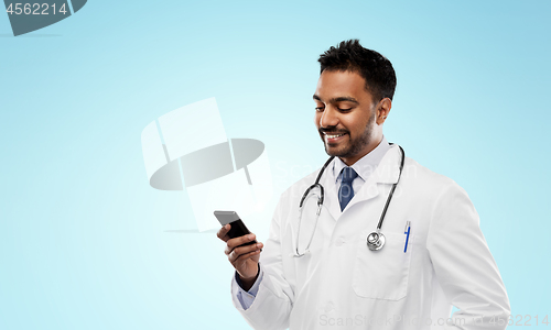 Image of smiling indian male doctor with smartphone