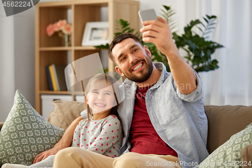 Image of father and daughter taking selfie at home