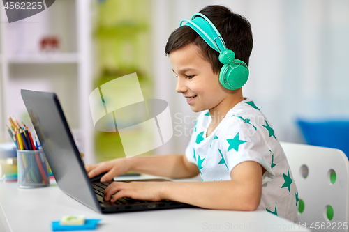 Image of boy in headphones playing video game on laptop
