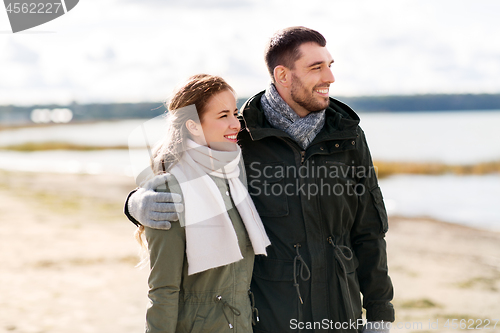 Image of smiling couple hugging on autumn beach