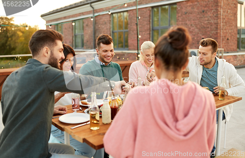 Image of friends having dinner or rooftop party in summer