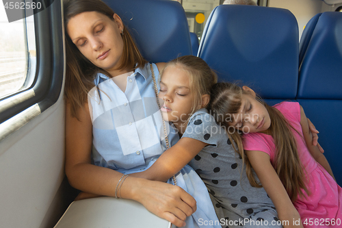 Image of Mom and two daughters fell asleep in an electric train car