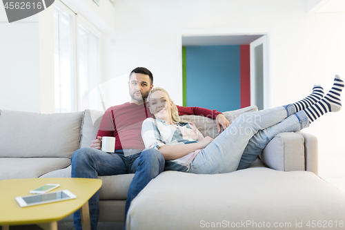 Image of couple hugging and relaxing on sofa