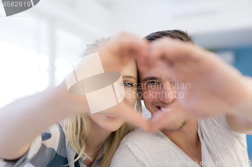 Image of couple making heart with hands