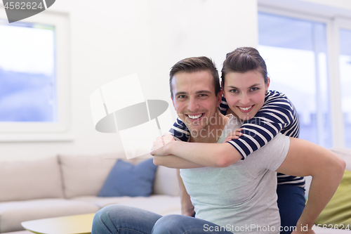 Image of handsome man piggybacking his girlfriend