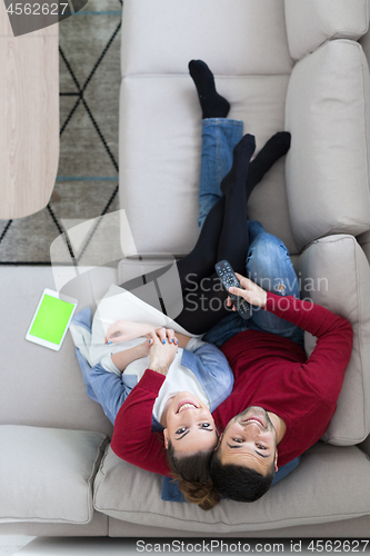 Image of Young couple on the sofa watching television top view