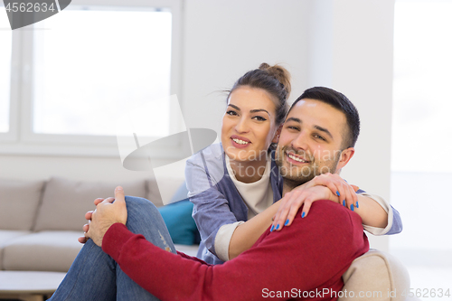 Image of couple hugging and relaxing on sofa