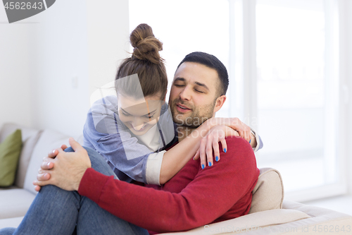 Image of couple hugging and relaxing on sofa