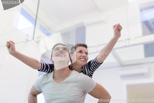 Image of handsome man piggybacking his girlfriend