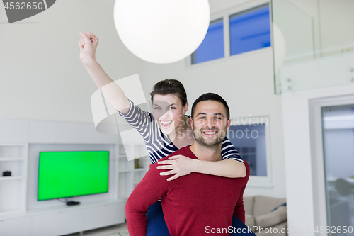 Image of handsome man piggybacking his girlfriend