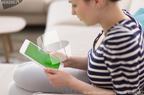 Image of woman on sofa using tablet computer
