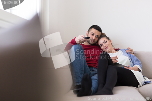 Image of Young couple on the sofa watching television