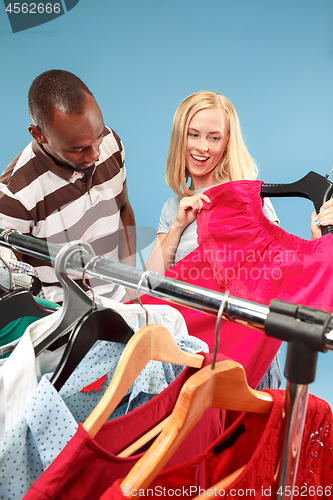 Image of The young pretty girl looking at dresses and try on it while choosing at shop