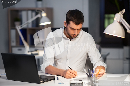 Image of businessman with papers working at night office