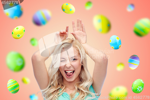 Image of happy smiling young woman making easter bunny ears