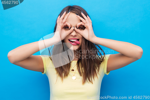 Image of young woman looking through finger glasses