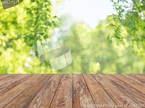 Image of wooden table with blurred summer park background