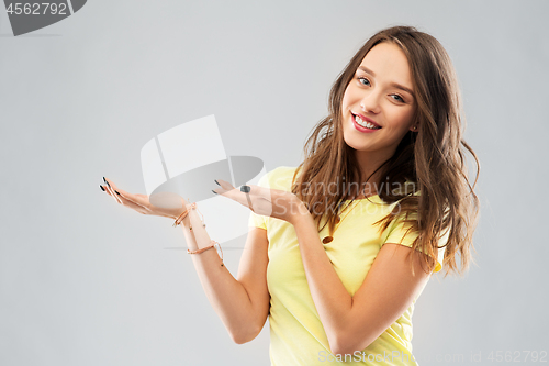 Image of happy teenage girl holding something imaginary