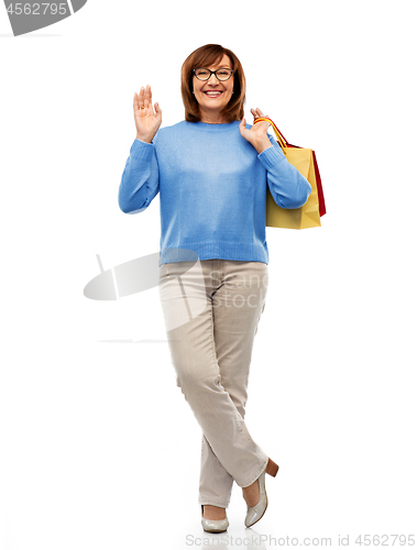 Image of senior woman with shopping bags isolated on white