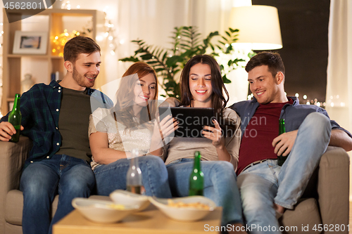 Image of friends with tablet computer drinking beer at home