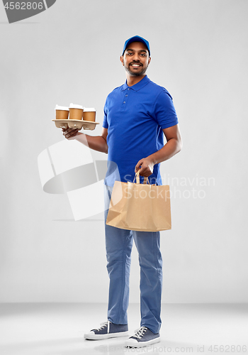 Image of happy indian delivery man with food and drinks