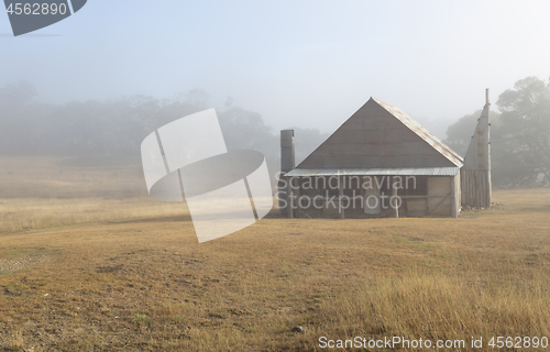 Image of Log hut in Snowy Mountains with early morning fog