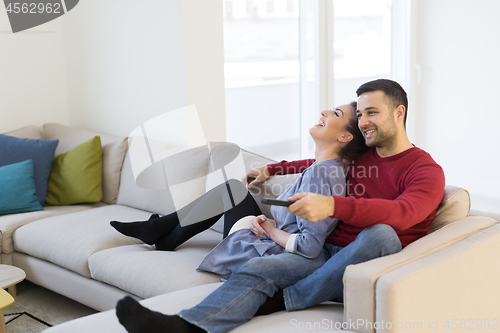 Image of Young couple on the sofa watching television