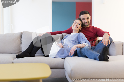 Image of couple hugging and relaxing on sofa