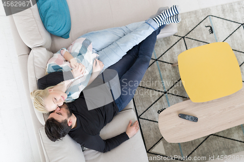 Image of Young couple on the sofa watching television top view