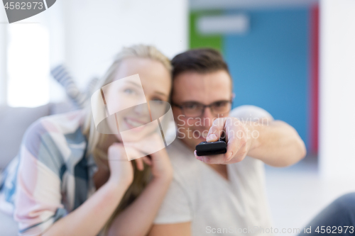 Image of Young couple on the sofa watching television