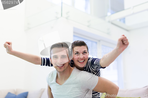 Image of handsome man piggybacking his girlfriend