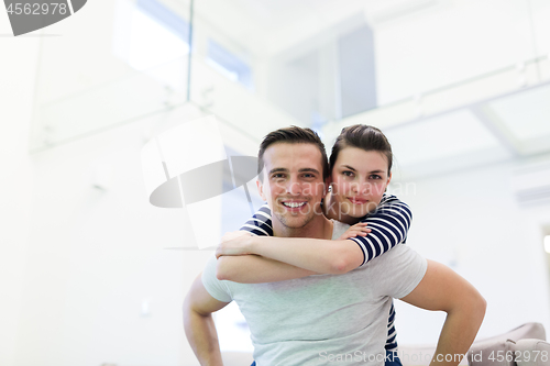 Image of handsome man piggybacking his girlfriend