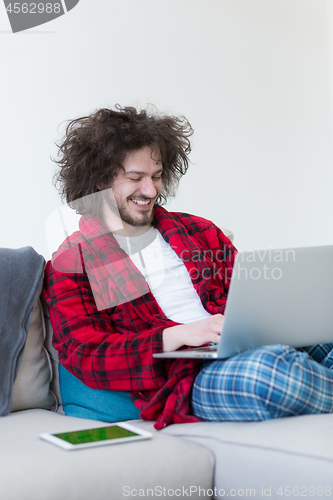 Image of man freelancer in bathrobe working from home