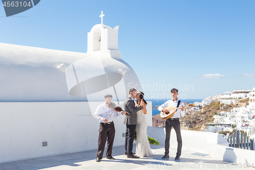 Image of Bride and groom dansing on wedding ceremony on Santorini island, Greece.